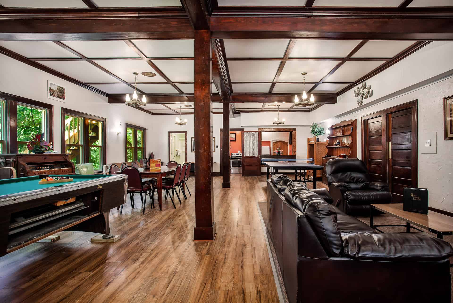 A spacious and well-appointed lodge common area with a pool table, dining space, comfortable seating, and a ping pong table.